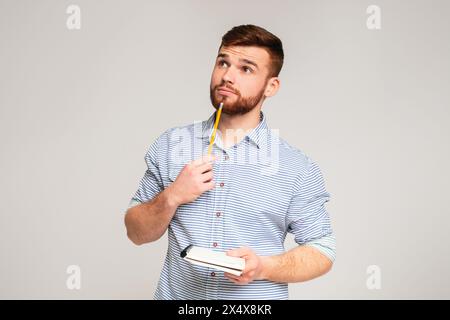 Young man thinking about checklist what to do Stock Photo