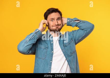 Man talking on phone and touching his head Stock Photo