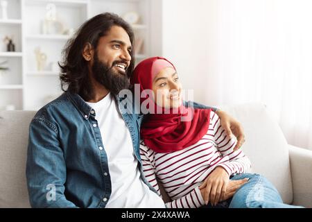 A Man and a Woman Sitting on a Couch, Hugging Stock Photo