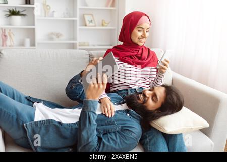 Young man lies down with his head in woman lap Stock Photo