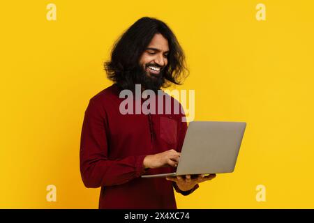 Man With Long Hair and Beard Using a Laptop Stock Photo