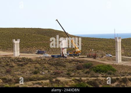 Almeria, Spain - May 25, 2023: A construction site showcasing a towering crane overlooking the area, surrounded by workers in hard hats and machinery, Stock Photo