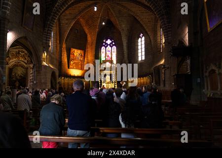 Langeac, France - May 27, 2023: A diverse group of people are standing in front of a grand Catholic church in France. Stock Photo