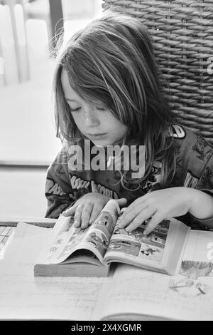 Italy, Sicily; 8 years old male child doing his homework on a table at home Stock Photo