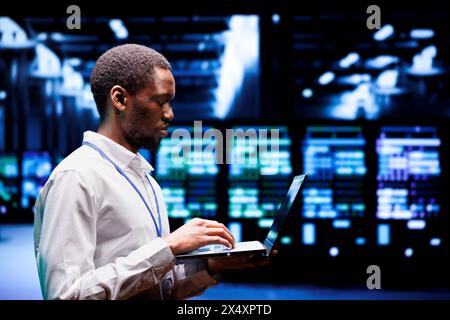 African american system administrator typing supercomputer hub ...