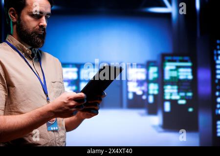 Adept system administrator doing maintenance on interlinked computers creating server network. Data storage service business using parallel computing to perform complex computing operations Stock Photo