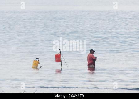 Subsistence or artisanal fishing is small scale marine harvest by individual fishermen, like this local man in Costa Rica catching fish in Golfo Dulce. Stock Photo