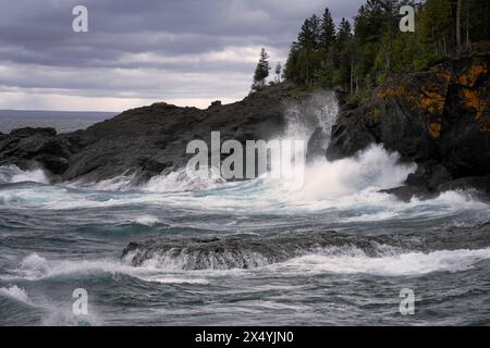 Autumn storm driven waves on Lake Superior in Michigan's Upper Peninsula of Marquette County explode against the Black Rocks at Presque Isle Park. Stock Photo