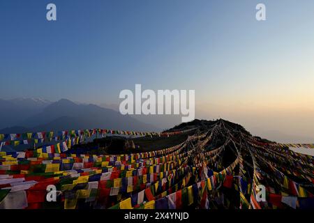 Rows of colorful Tibetan Buddhist flags on Ama Yangri mountain top with the Langtang Himalayan range on the left Stock Photo
