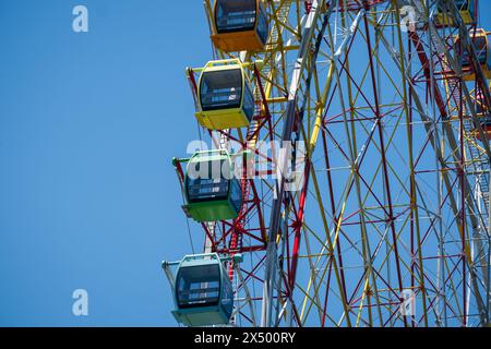 Ferris Wheel Over Blue Sky. Multicolored booths of a Ferris wheel over a blue sky. Carousel. Colorful Ferris wheel on blue sky. Stock Photo