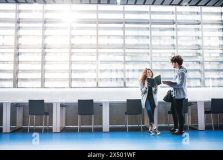 Young university students meeting in library to study together, preparing for final exam. Study group. Teamwork skills. Stock Photo