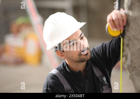 Construction worker working taking measures with a meter Stock Photo
