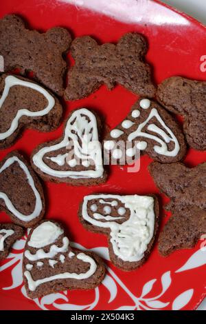 Baked gingerbread cookies are lying on a plate. Some are decorated with white icing. Cooking gingerbread. Stock Photo