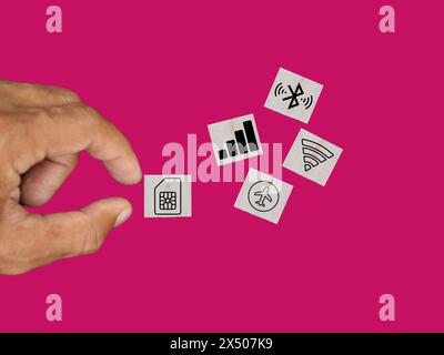 An icon of a SIM card is displayed on a wooden block, accompanied by icons representing Bluetooth, Wi-Fi, aeroplane mode, and a signal indicator. Stock Photo