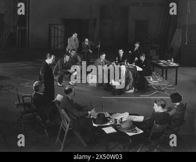 Cast members including (from left to right) ANTHONY BUSHELL, IAN MacLAREN, DAVID MANNERS and BILLY BEVAN at a  script read- through before the start of filming JOURNEY'S END 1930 Director JAMES WHALE (at table right) Play R. C. SHERRIFF Producer GEORGE PEARSON (at table left) Welsh-Pearson Production / Tiffany-Stahl Stock Photo