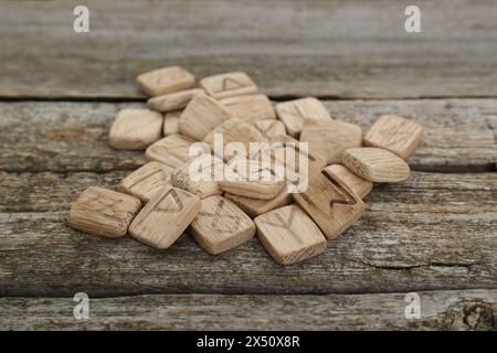 Pile of runes with different symbols on wooden table Stock Photo