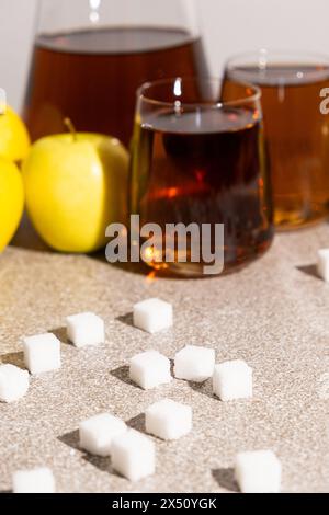 Sugar content in fruit juices. Sugar cubes and glasses of apple juice. Stock Photo