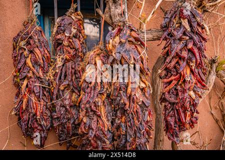 Close-up view of arrangements of dried chili peppers, called ristras, hanging  from wooden ceiling in Albuquerque New Mexico. Stock Photo