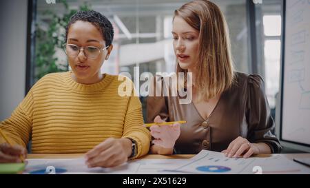 Point of View from Camera with Two Diverse Project Managers Making a Video Call in Creative Office Environment. Happy Female Caucasian and Latin Specialists Working with Colleague Over a Live Camera. Stock Photo