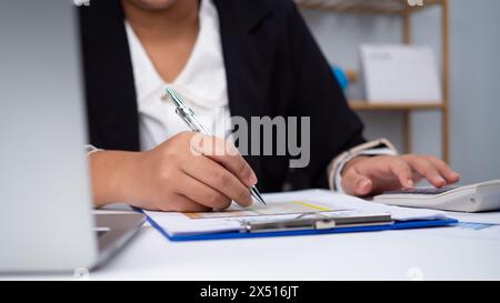 Photo close up hands of business woman working on desk office with using a calculator to calculate the numbers, Finance accounting concept, Accounting Stock Photo