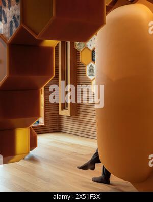 A Visitors feet can be seen poking out of the seating pod, timber floor and cladding details. The Beezantium at The Newt, Bruton, United Kingdom. Arch Stock Photo