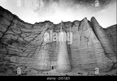 White stone formations of Plaza Blanca loom large above a lone hiker, in Abiquiu New Mexico Stock Photo