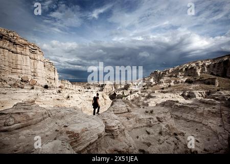 A hiker navigates the white stone formations of Plaza Blanca, in Abiquiu New Mexico Stock Photo