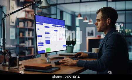 Handsome Caucasian Male Specialist Working on Desktop Computer in Creative Home Living Room. Freelance Male is Checking His Calendar to Make an Appointment with New Clients and Employer. Stock Photo