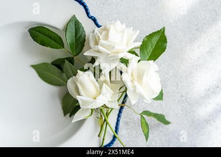 Minimalistic table setting with white roses Stock Photo