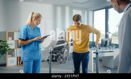 Hospital Physical Therapy: Determined Male Patient with Injury Successfully Walks Holding Parallel Bars. Physiotherapist, Rehabilitation Doctor Encourage, Applaud Disabled Person. Stock Photo