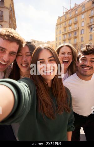 Crowd of young people happy smiling and having fun taking selfie together in front of building. Stock Photo