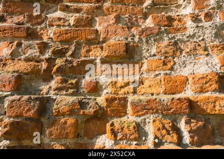 The image captures the effects of time on a structure,. an old, weathered brick wall. Each brick tells a story of age and exposure to the elements, cr Stock Photo