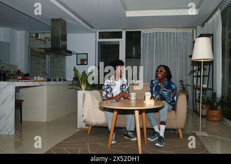 Young Black couple spending evening at home, having tea and chatting Stock Photo