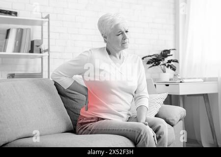 Senior woman suffering from backache at home Stock Photo