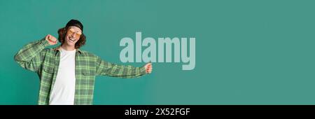 Cheerful young man in casual clothes on turquoise background Stock Photo