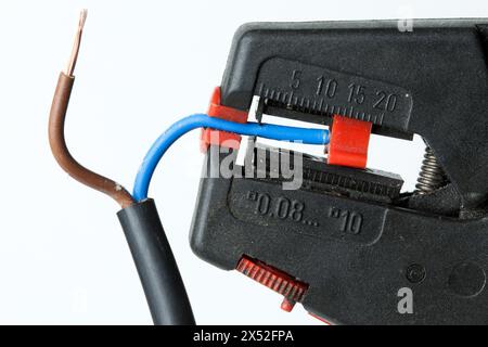 A wire stripper with wire. It makes it easier to precisely remove insulation from cables without damaging the conductor. Stock Photo
