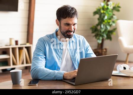 Businessman Using Laptop Computer at Table at Office Stock Photo