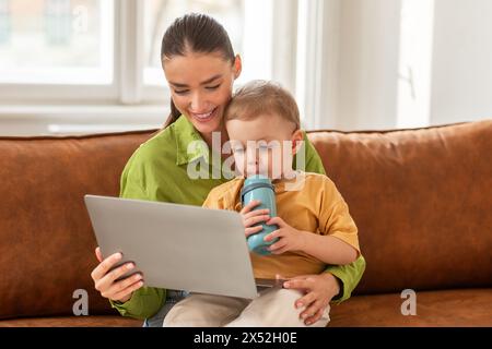 Woman and Child Using Laptop on Couch Stock Photo