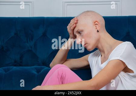 Woman with shaved head sit sadly struggle of chemo side effects Stock Photo