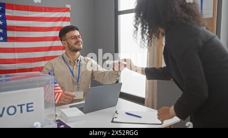 Man and woman engaging in voting process inside a room with american flag and ballot box. Stock Photo