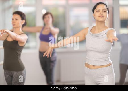 Young female amateur ballet dancer practicing moves at group session Stock Photo
