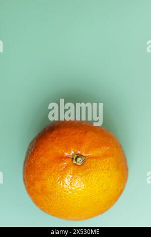 A wonderful ripe orange on a smooth green surface Stock Photo