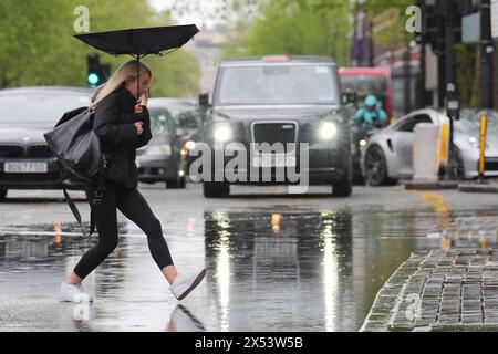 File photo dated 28/04/24 of a person walking through rainwater in central London. Retail sales dropped 4% in April versus the previous year, dampened by a spell of wet weather and an early Easter bank holiday. The year-on-year drop is set against a growth of 5.1% in April 2023, but was artificially worsened by the earlier timing of Easter, which previously pushed March sales unusually high, according to the British Retail Consortium (BRC)-KPMG Retail Sales Monitor. Issue date: Tuesday May 7, 2024. Stock Photo
