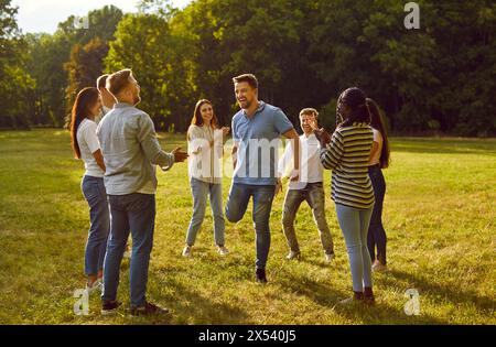 Group of excited happy friends students or colleagues having fun in nature in summer park. Stock Photo