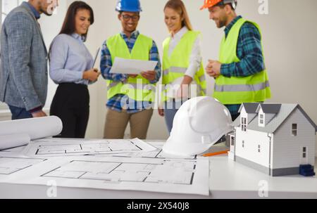 Engineers and architects discussing plans for a new home and working on a building site Stock Photo