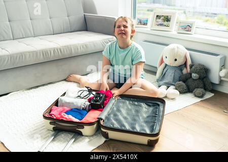 Little girl crying while unpacking her suitcase after vacation. Selected Focus. High quality photo Stock Photo