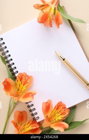 Guest list. Notebook, pen and beautiful flowers on beige background, flat lay. Space for text Stock Photo