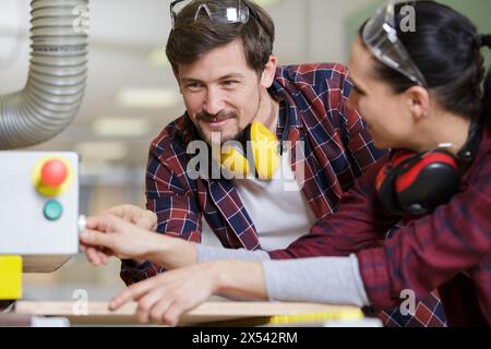man and woman checking machine in factory Stock Photo