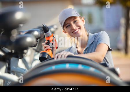 happy woman fixing a bicycle Stock Photo