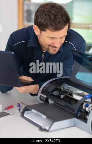 hardware repairman repairing broken printer Stock Photo